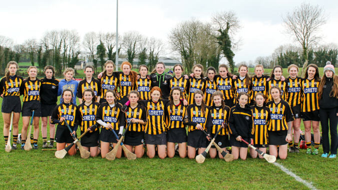 Eine Gruppe junger Schülerinnen der Loreto Secondary School steht in Fußballuniform auf einem Rasenplatz mit Bäumen im Hintergrund.