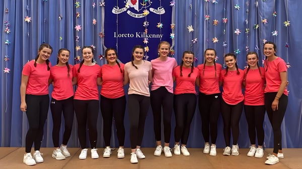 Eine Gruppe junger Schülerinnen der Loreto Secondary School steht in roten Oberteilen vor einem Sternenhintergrund.