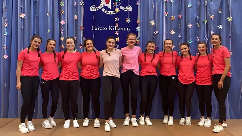 Eine Gruppe junger Schülerinnen der Loreto Secondary School steht in roten Oberteilen vor einem Sternenhintergrund.