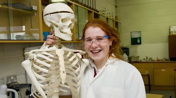 Eine Schülerin der Loreto Secondary School in Cork steht neben einem Skelettmodell im Klassenraum.