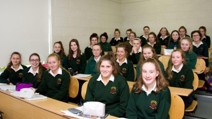 Eine Gruppe junger Schülerinnen in Schuluniformen sitzt in einem Klassenraum der Loreto Secondary School in Cork.