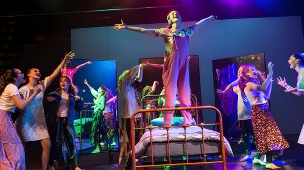 Eine Darstellerin steht auf einer erhöhten Bühne während einer Theateraufführung an der Loretto School.