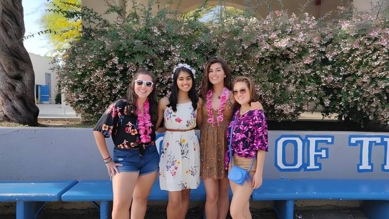 Vier Schülerinnen stehen vor einem Blumenmuster auf dem Gelände des Los Angeles Unified School District.