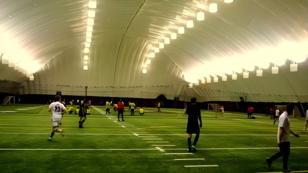 Die Sporthalle mit Kunstrasen der École secondaire publique Louis-Riel ist innen groß und gut beleuchtet.