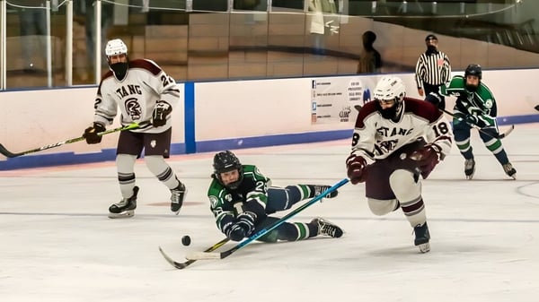 Schüler der Lowell Catholic High School spielen ein Hockeyspiel in der Halle auf dem Eis.