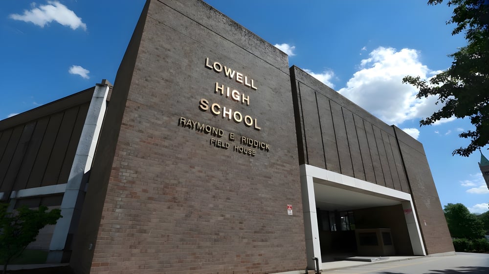 Das Backsteingebäude der Lowell High School steht vor einem blauen Himmel mit vereinzelten Wolken.