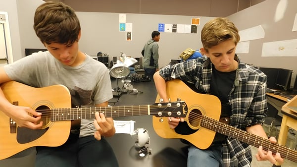 Zwei Schüler spielen akustische Gitarren in einem Musikraum des Loyalist Collegiate & Vocational Institute.