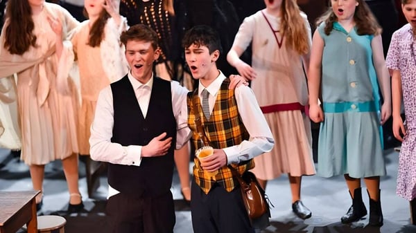 Schülerinnen und Schüler der LVS Ascot bei einem Bühnenauftritt in formeller Kleidung.