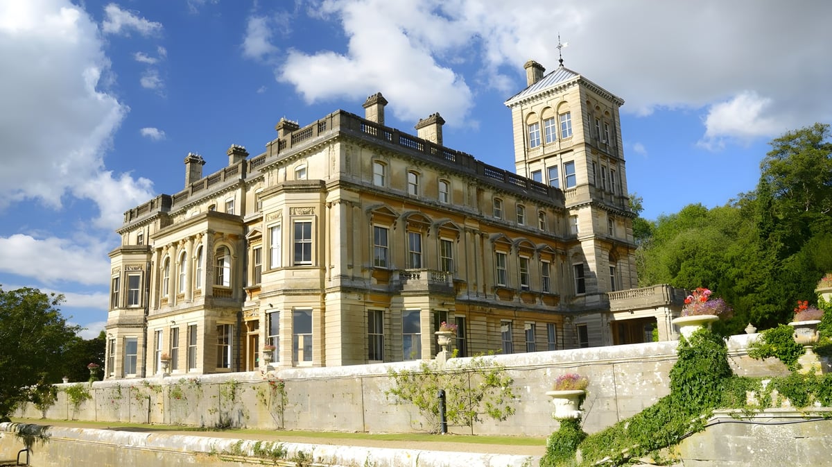 Das prächtige Gebäude mit kunstvoller Architektur auf dem Campus der LVS Ascot ist von grüner Vegetation umgeben.