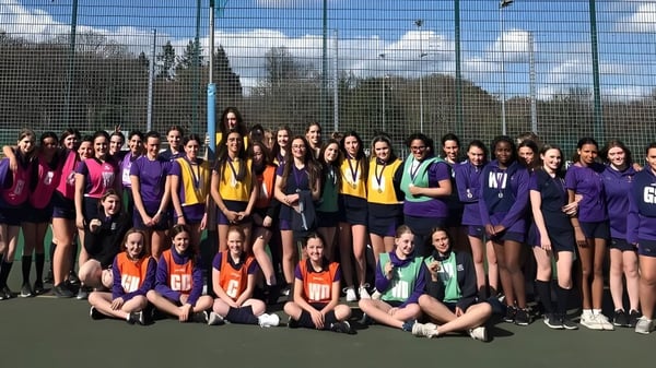 Eine große Gruppe junger Schülerinnen in bunten Sportuniformen auf dem Sportfeld der LVS Ascot.