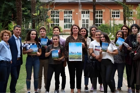 Eine Gruppe Schülerinnen und Schüler steht draußen vor dem Gebäude des Lycée Gabriel Fauré mit einem ausgestellten Gemälde.