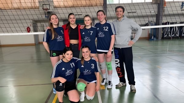 Die Volleyballmannschaft des Lycée Gabriel Fauré posiert gemeinsam in einer Sporthalle mit sichtbarem Basketballkorb.