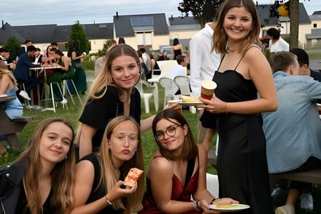 Eine Gruppe junger Frauen in formeller Kleidung posiert gemeinsam im Garten auf dem Campus des Lycée Immaculée Jean Paul II.