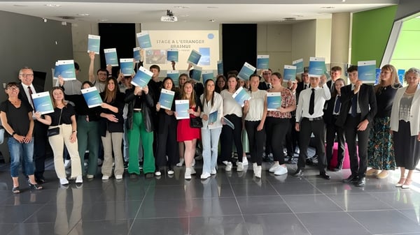 Eine Gruppe junger Menschen steht gemeinsam in einem Raum mit grüner Wand auf dem Campus des Lycée Immaculée Jean Paul II.