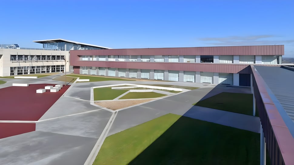 Das moderne mehrstöckige Gebäude mit buntem geometrischem Design auf dem Campus des Lycée Jean Brito.