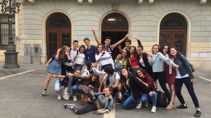 Eine Gruppe junger Menschen posiert vor dem historischen Gebäude auf dem Campus des Lycée Jean Brito.