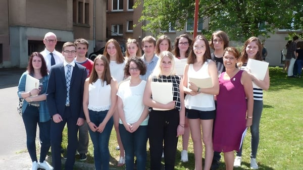 Eine Gruppe Schülerinnen und Schüler steht gemeinsam im Freien vor einem Gebäude auf dem Campus des Lycée Saint Antoine.