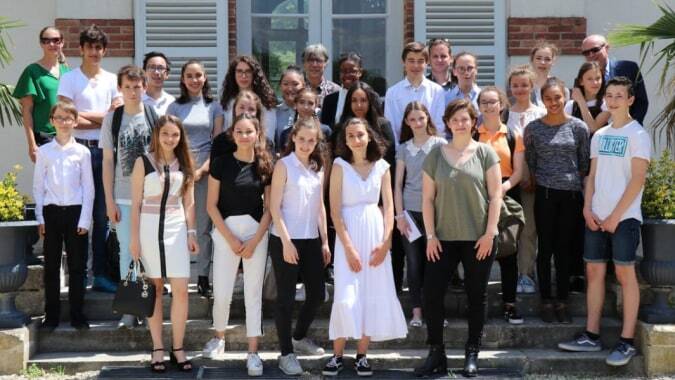 Eine Gruppe von Schülerinnen und Schülern steht vor dem Backsteingebäude des Lycée Sainte Thérèse.