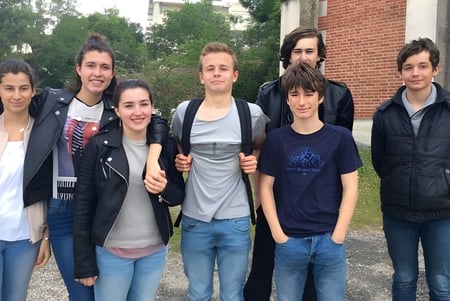 Eine Gruppe Schülerinnen und Schüler steht vor einem Backsteingebäude auf dem Gelände des Lycée St Elme.