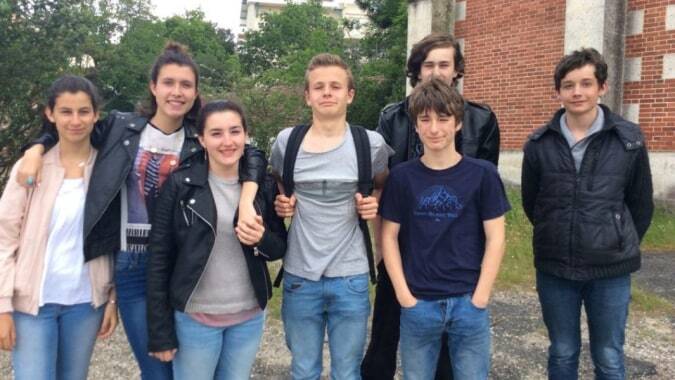 Eine Gruppe Schülerinnen und Schüler steht vor einem Backsteingebäude auf dem Gelände des Lycée St Elme.