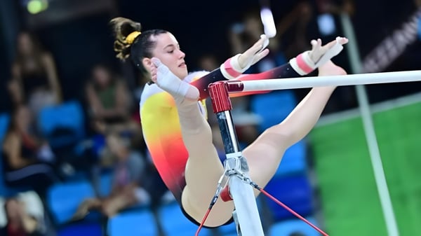 Eine Turnerin des Lycée St Elme übt am ungleichen Barren in der Sporthalle.
