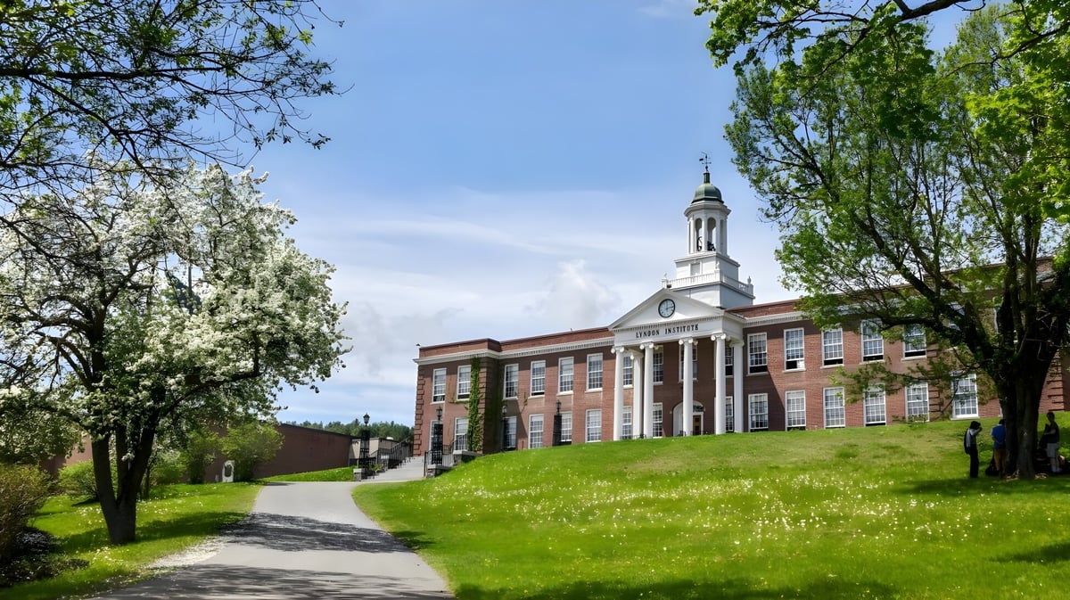 Das historische Hauptgebäude befindet sich auf dem grünen Campus des Lyndon Institute mit einem gewundenen Weg davor.