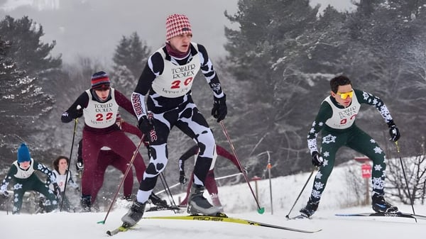 Schüler des Lyndon Institute nehmen an einem Skirennen durch eine verschneite Waldlandschaft teil.