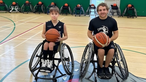 Zwei Schüler in Rollstühlen spielen Basketball auf dem Spielfeld der Macdonald High School.
