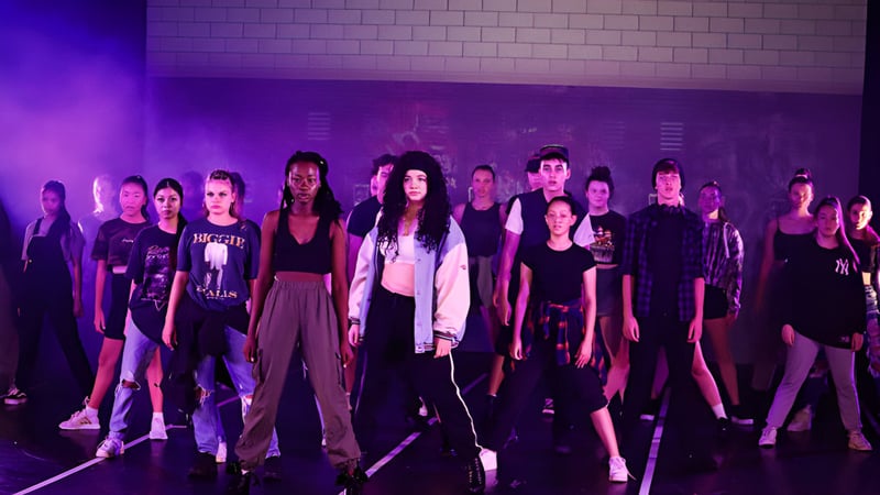 Eine Gruppe Schülerinnen steht in einem düster beleuchteten Raum auf dem Campus der MacGregor State High School.