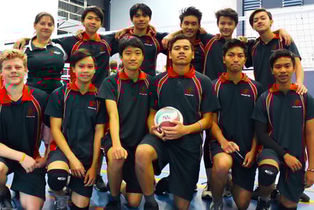 Eine Gruppe junger Athleten posiert in der Sportanlage der MacGregor State High School in ihren einheitlichen Trainingsanzügen.