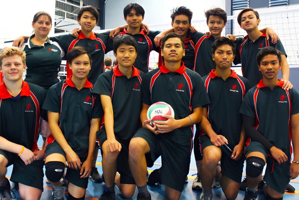 Eine Gruppe junger Athleten posiert in der Sportanlage der MacGregor State High School in ihren einheitlichen Trainingsanzügen.