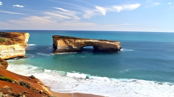 Eine beeindruckende Küstenlandschaft mit Felsformationen und türkisfarbenem Wasser unter blauem Himmel.