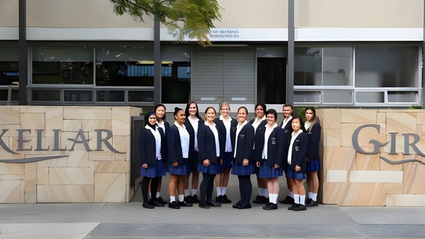Eine Gruppe Schülerinnen des Mackellar Girls Campus steht vor einem Gebäude mit der Aufschrift Mackellar Girls.