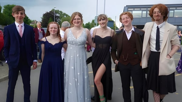 Eine Gruppe gut gekleideter Personen posiert vor einem Gebäude auf dem Campus des Macleans College.