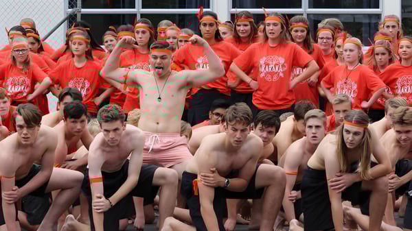 Eine Gruppe von Schülerinnen und Schülern des Mahurangi College trägt rote T-Shirts und versammelt sich im Außenbereich.