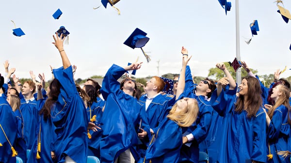 Eine Gruppe von Absolventen der Malanda State High School wirft ihre blauen Hüte in den Himmel.