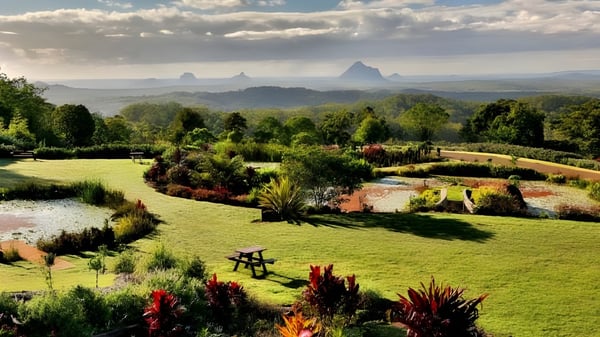 Ein gepflegter Garten mit bunten Blumen vor einem Hügelpanorama auf dem Gelände der Maleny State High School.