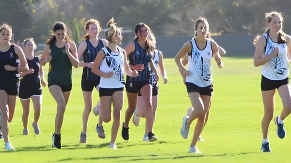 Eine Gruppe junger Athletinnen trainiert gemeinsam auf dem Sportplatz des Manawatu College.