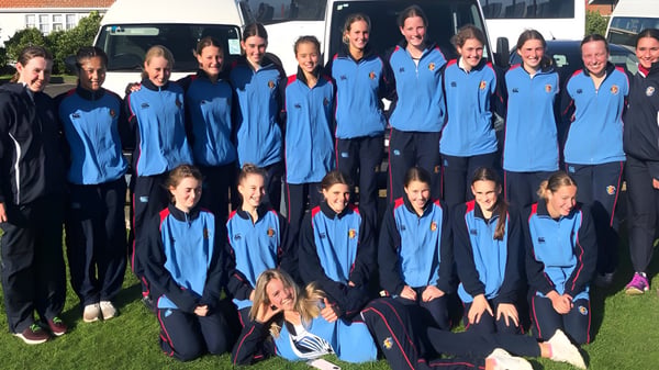 Eine Gruppe Schüler in blauen Uniformen steht gemeinsam vor dem Gebäude des Manawatu College.