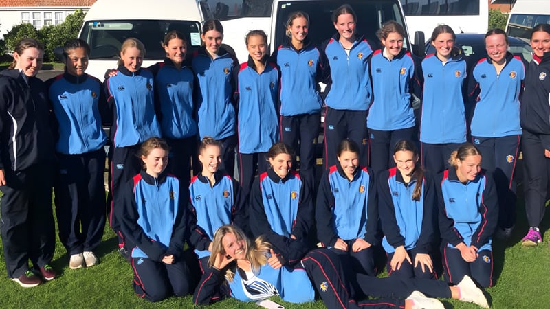 Eine Gruppe Schüler in blauen Uniformen steht gemeinsam vor dem Gebäude des Manawatu College.