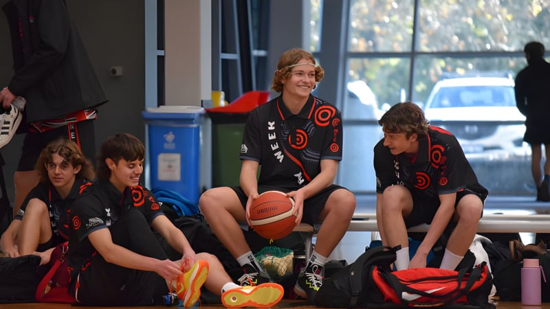 Schüler der Manea Senior College bereiten sich in einem Raum mit Basketball und Blick nach draußen auf eine Sportaktivität vor.
