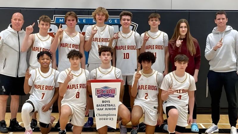 Eine Gruppe junger Basketballspielerinnen und -spieler posiert vor dem Apple Ridge Logo auf dem Campus der Maple Ridge Secondary School in Ontario.