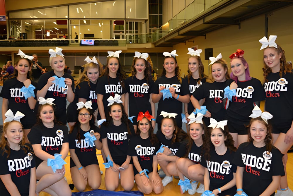 Eine Gruppe Schülerinnen der Maple Ridge Secondary School mit schwarzen Shirts und Hasenohren posiert in einer Sporthalle.