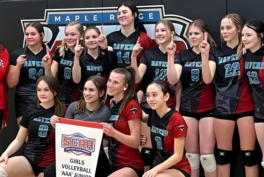 Eine Gruppe weiblicher Volleyballspielerinnen posiert gemeinsam vor dem Schriftzug der Maple Ridge Secondary School in Ontario.