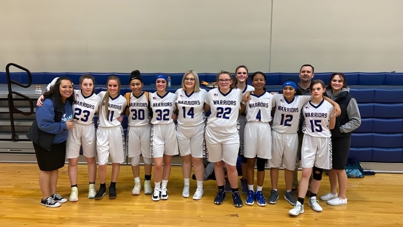 Eine Gruppe von jungen Basketballspielerinnen steht zusammen auf dem Basketballfeld der Maranatha Baptist Academy.