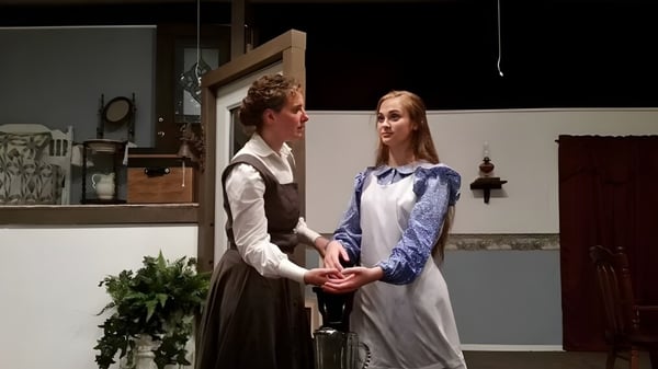 Ein Mann und eine Frau stehen in einem rustikalen Innenraum auf dem Campus der Maranatha Baptist Academy.