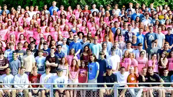 Eine Gruppe junger Menschen steht im Grünen zusammen auf dem Gelände der Marblehead High School.