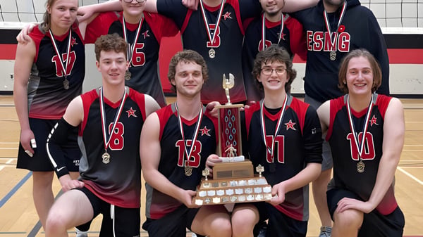 Eine Gruppe Schülerinnen und Schüler der École secondaire publique Marc-Garneau posiert mit einer Trophäe auf dem Basketballplatz.