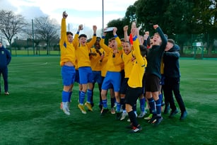 Eine Gruppe junger Fußballspieler feiert auf dem Sportplatz des Marian College gemeinsam.