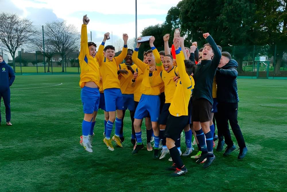Eine Gruppe junger Fußballspieler feiert auf dem Sportplatz des Marian College gemeinsam.